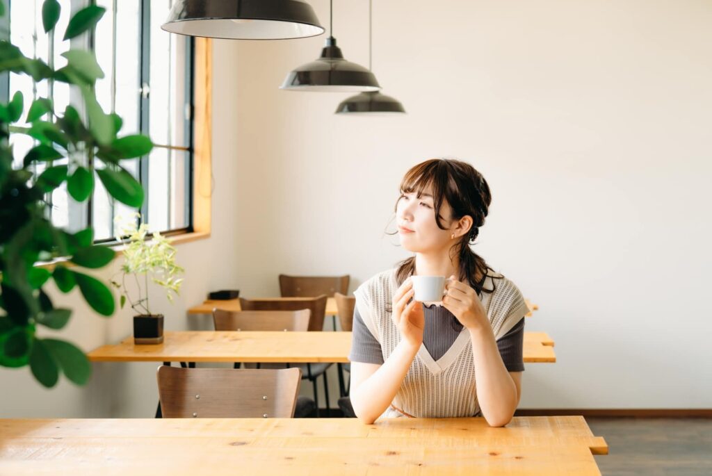 カフェでコーヒーを飲みながらくつろぐ女性
