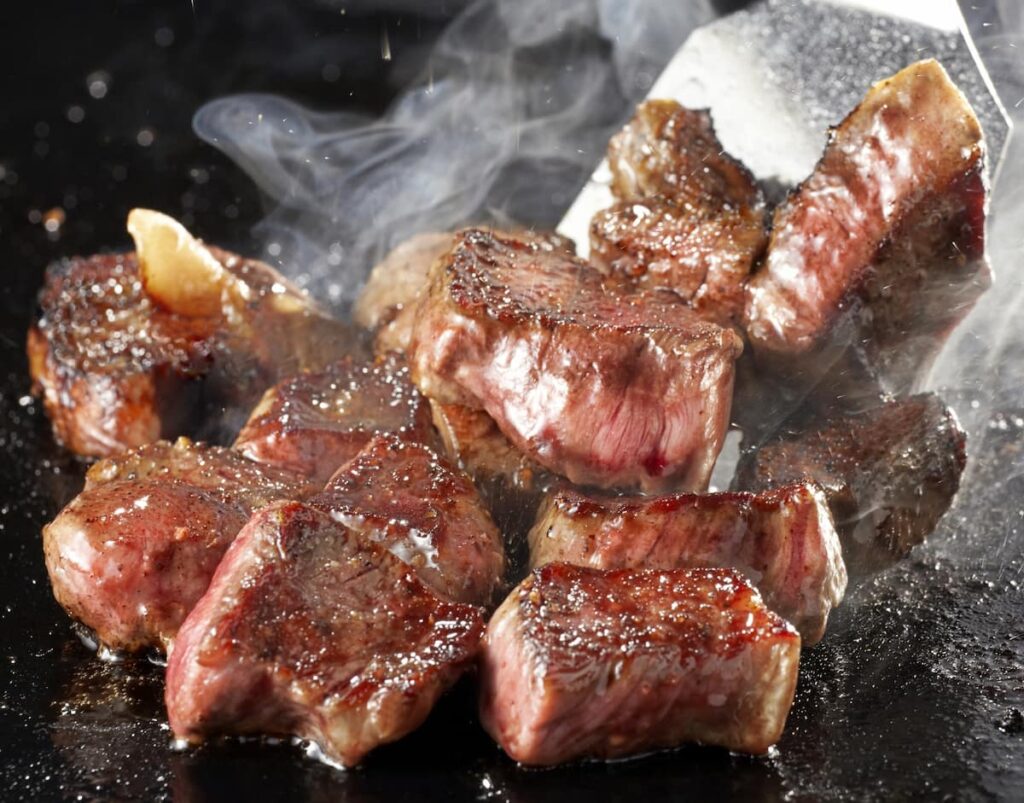 シンタマのステーキ。鉄板で焼いた赤身のサイコロステーキ