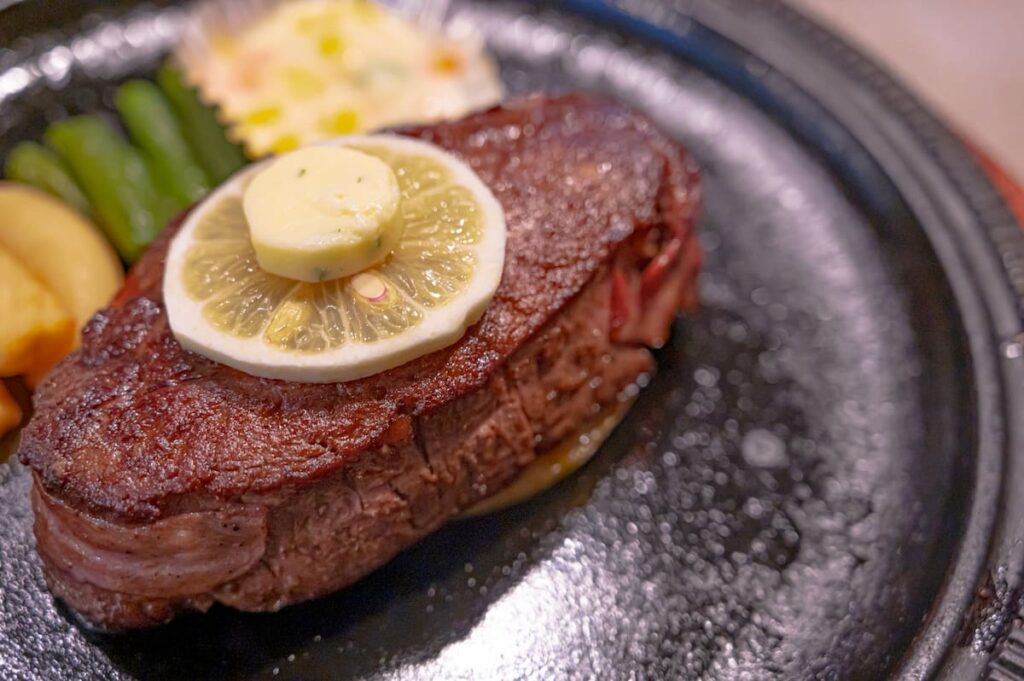 内もも肉を使ったステーキの盛り付け写真（鉄板で焼いたステーキ）