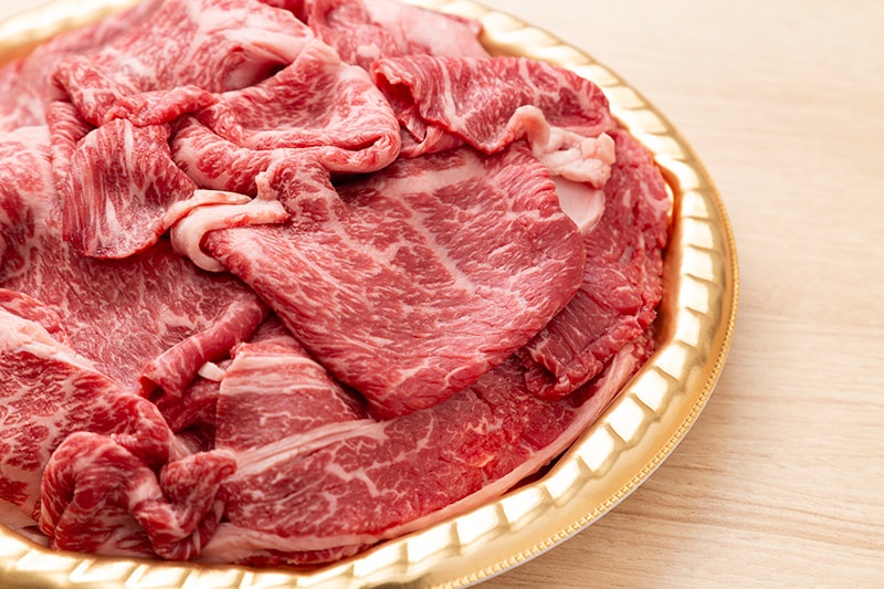 肩ロース肉のスライスを皿に盛り付けた写真（生肉）