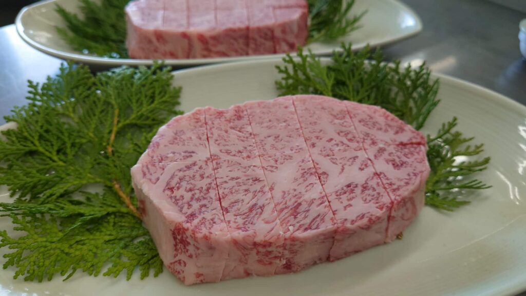 分厚い生のリブロース肉の写真。霜降りが入り、赤身と脂のバランスが美しい