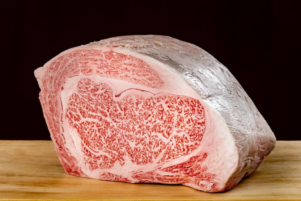 リブロースの塊肉をまな板の上に置いた写真。厚みがあり、サシが美しく入っている