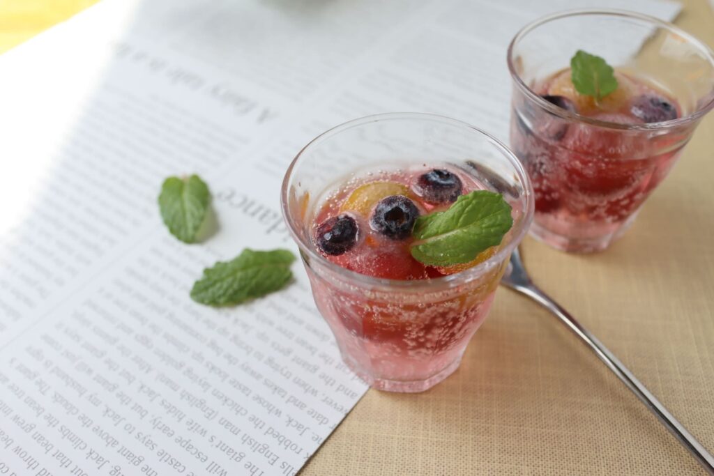 炭酸ジュースにフルーツとミントの葉を浮かべたグラス｜爽やかなドリンク