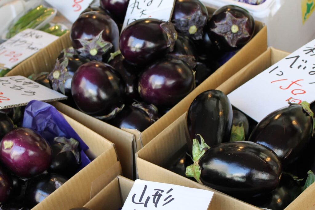 八百屋に並ぶ米茄子と丸ナス｜形とヘタの色の違い