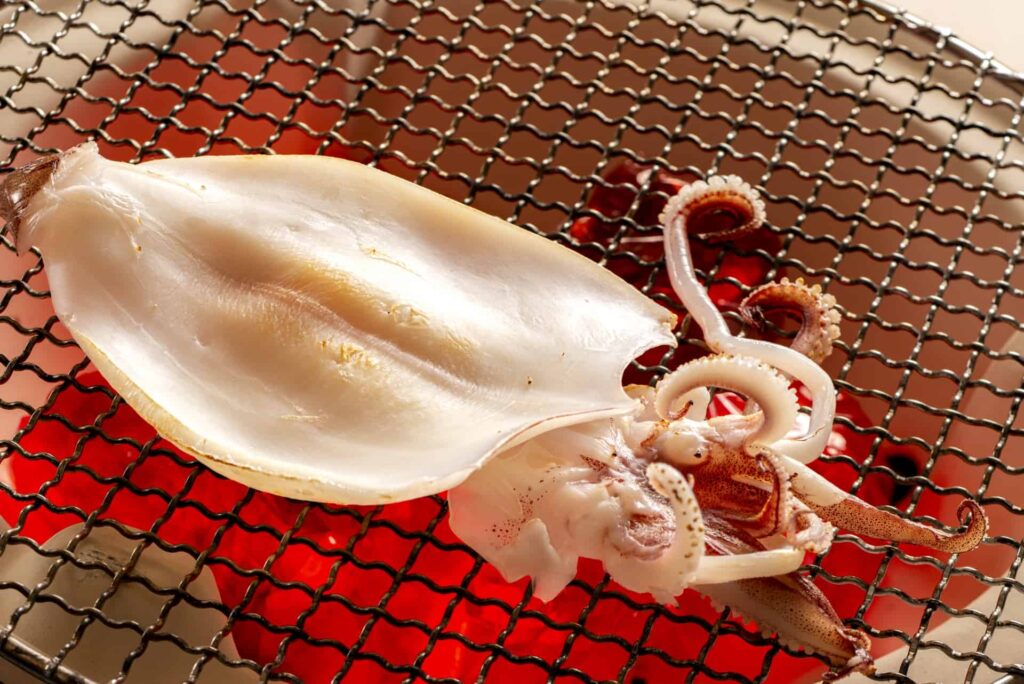 炭火で焼かれるスルメイカの一夜干し
