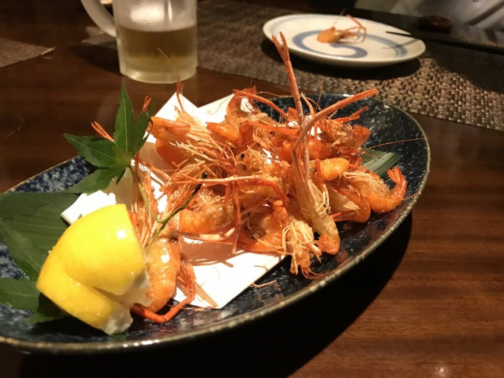 川海老の唐揚げにレモンを添えた盛り付け｜青じそと一緒に盛りつけ
