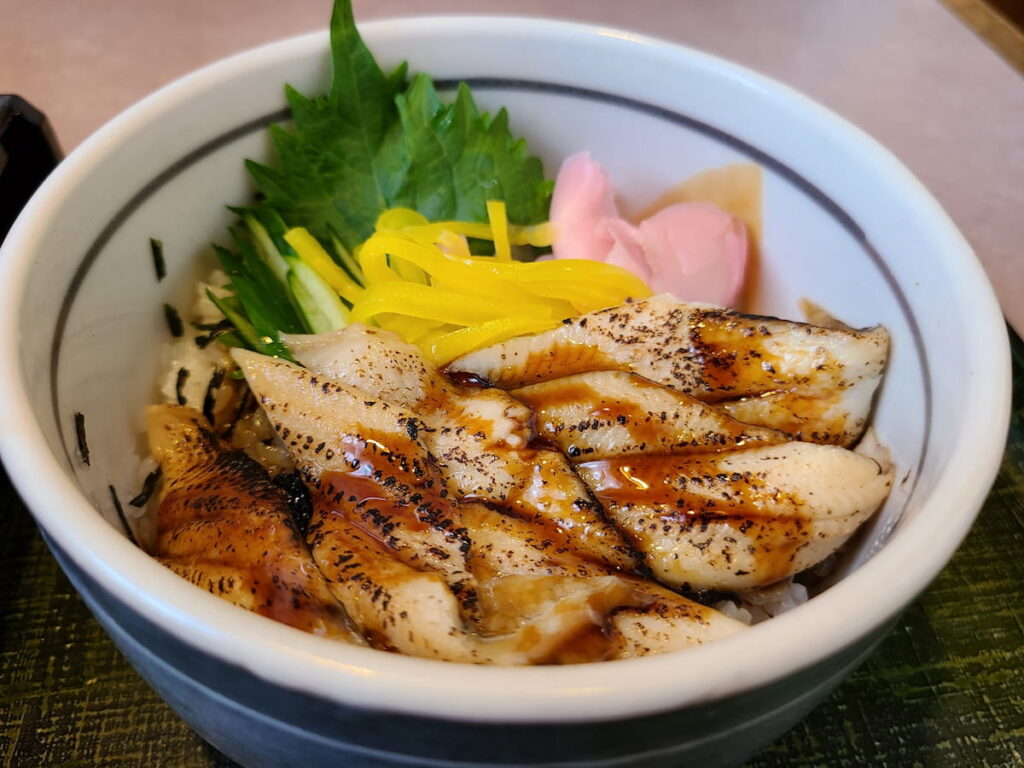 穴子丼に紫蘇・胡瓜・たくあん・ガリを添えた盛り付け