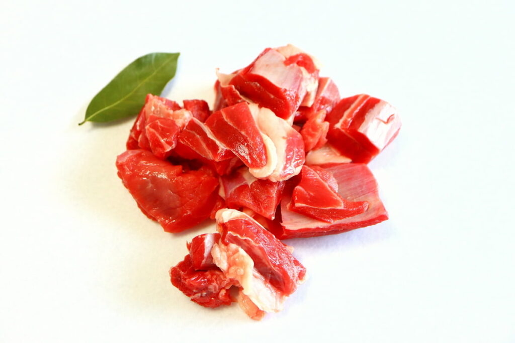 生の牛すね肉を一口大にカットした写真。赤身が中心でスジが多い