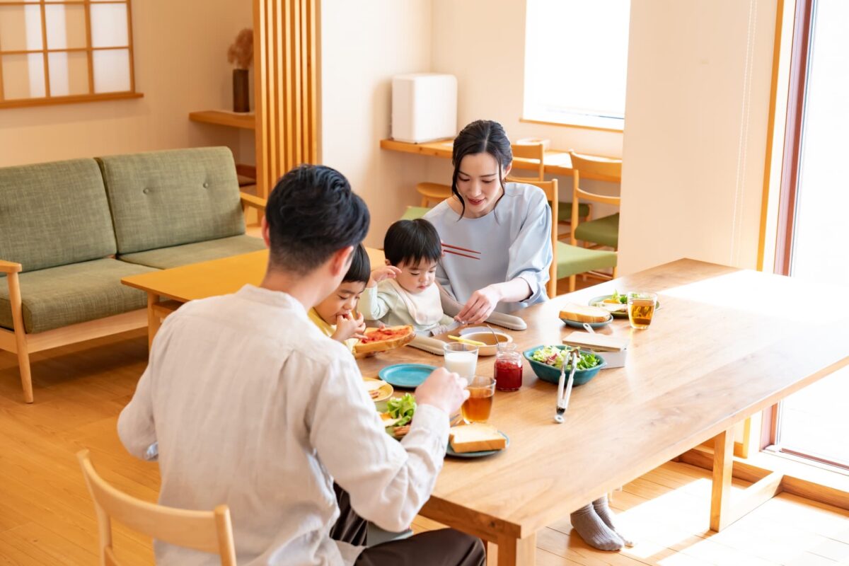 共働き家庭の親子が夕食を囲む食卓の風景｜忙しくても食事を大切にしたい家族のイメージ