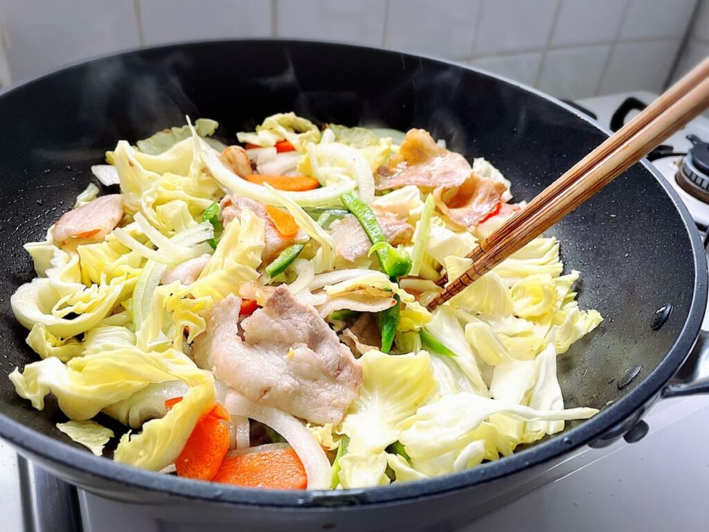 フライパンで野菜炒めを木箸で混ぜる調理の様子|まとめ・木箸の活用例