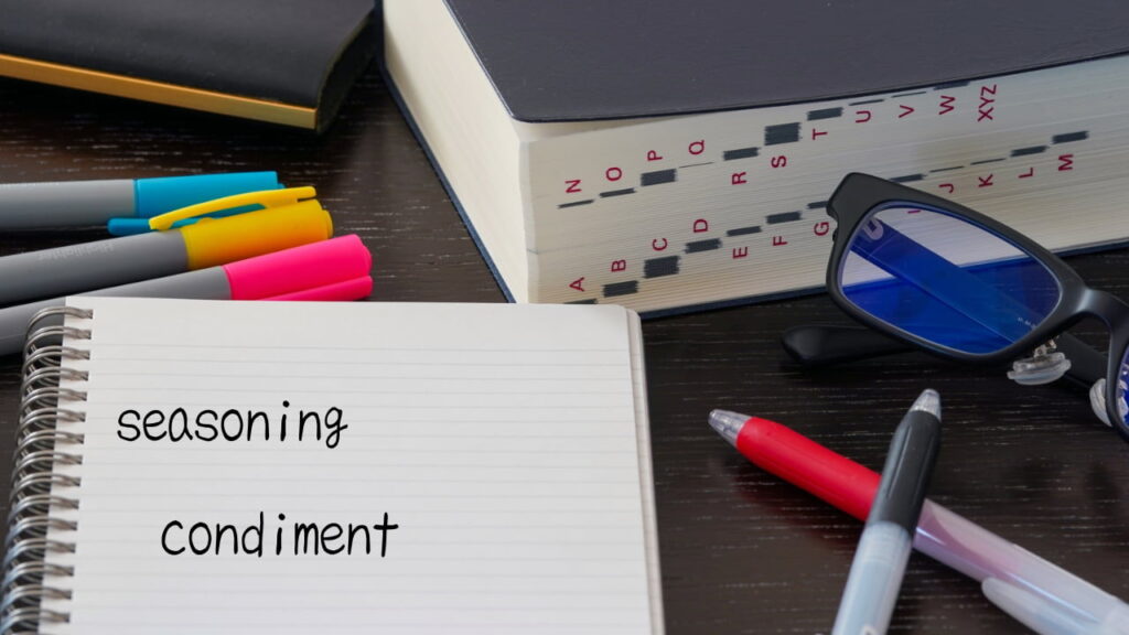 英単語「seasoning」と「condiment」が書かれたノートと辞書