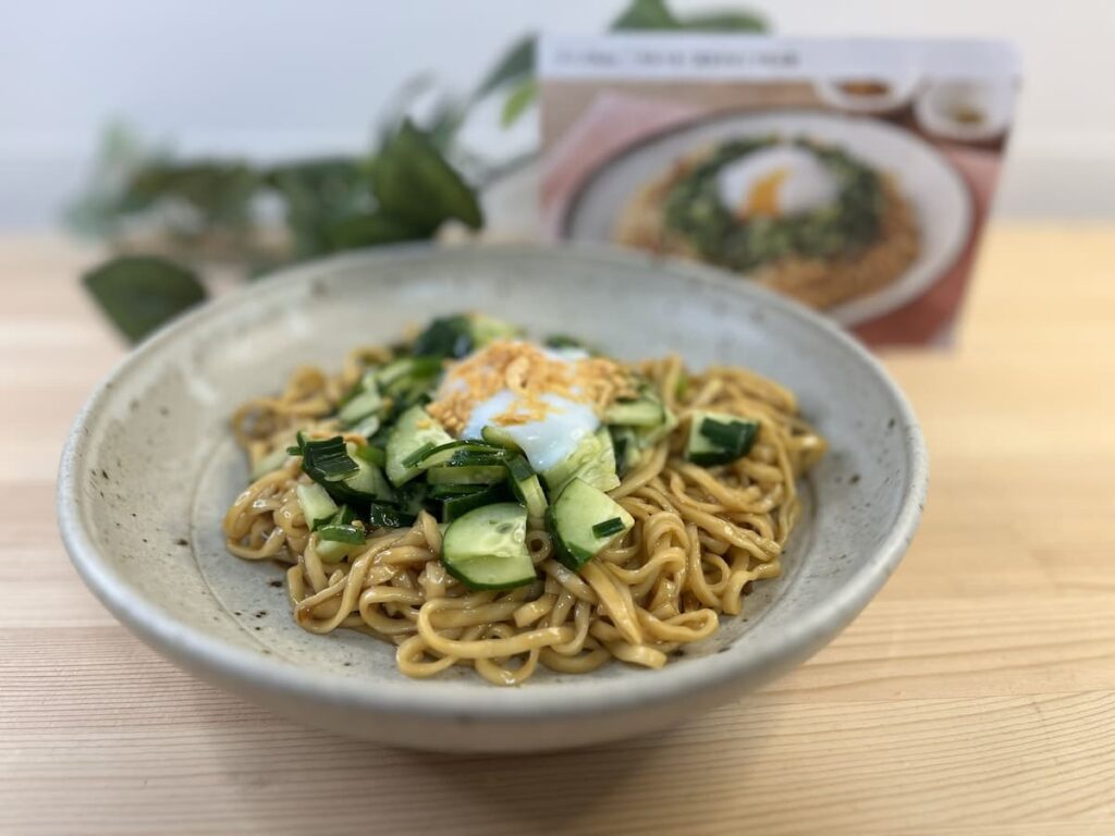 温玉を中央にのせたニラ和え麺の盛り付け写真｜Oisixミールキットの完成イメージ