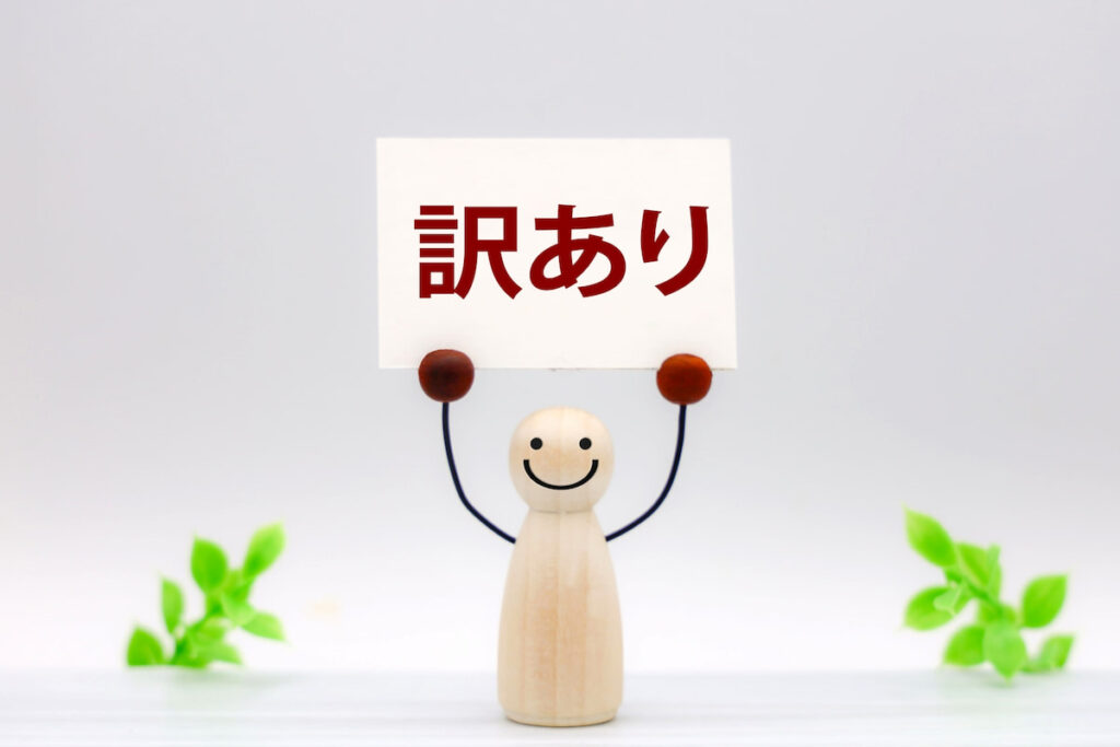 セール品「訳アリ」を掲げた人形。セール品を活用するイメージ