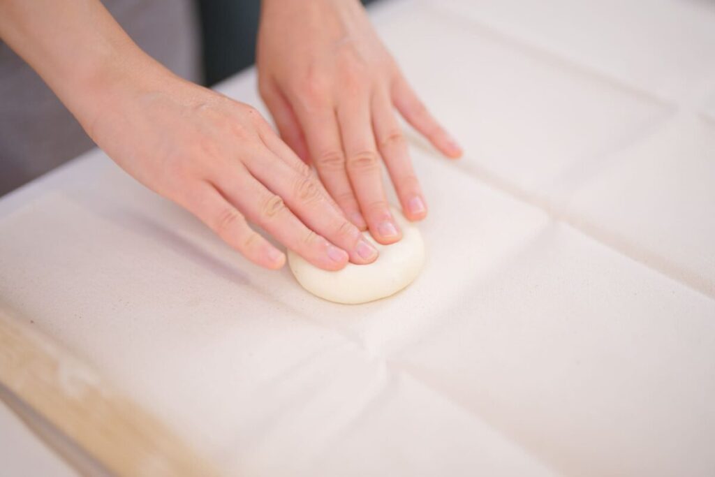 パン生地を手で成型している調理中の手元