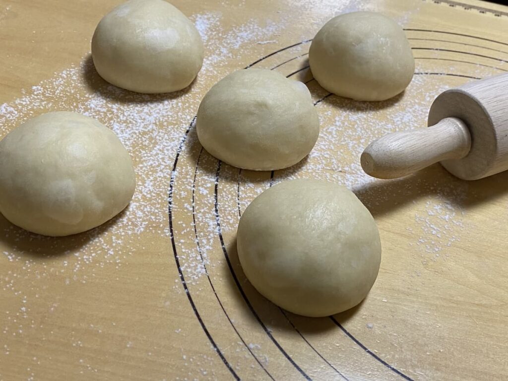手で丸められたパン生地のクローズアップ