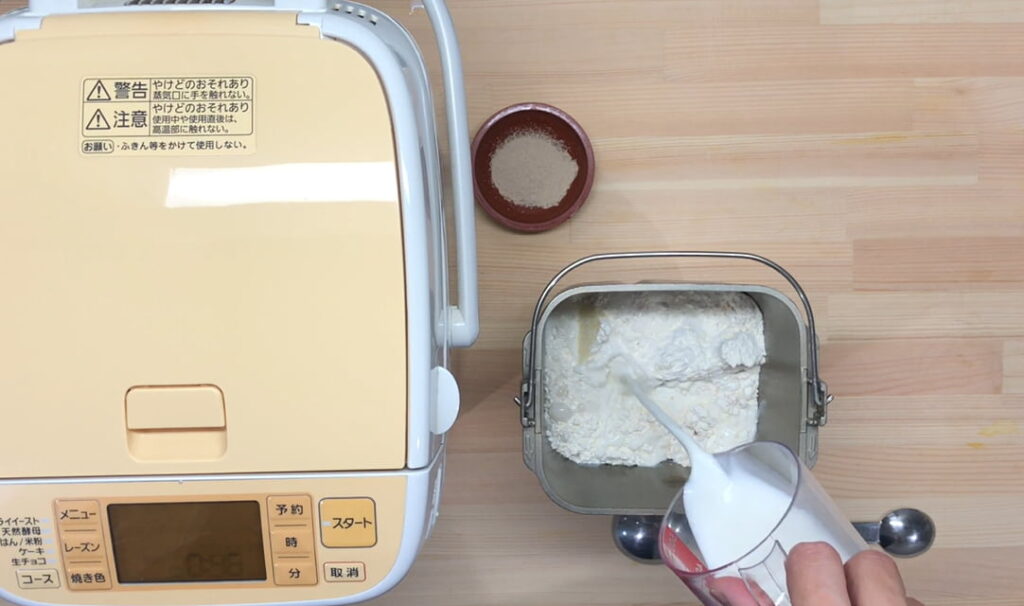 ホームベーカリーに魔法庵の食パンミックスと材料を入れている様子