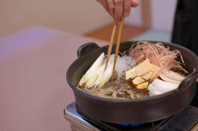 春らしく、新牛蒡や筍、新玉葱をすき焼き鍋に入れてる画像