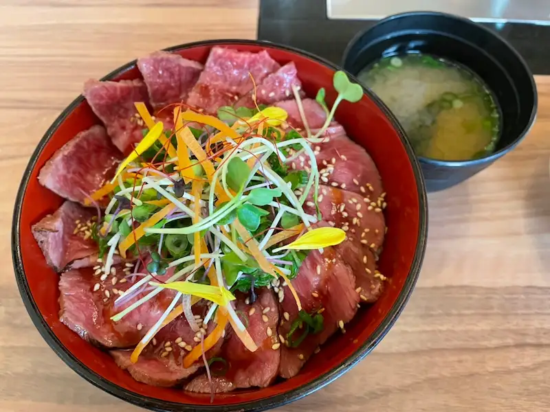 貝割れ大根や人参、ねぎなどを上に乗せたローストビーフ丼