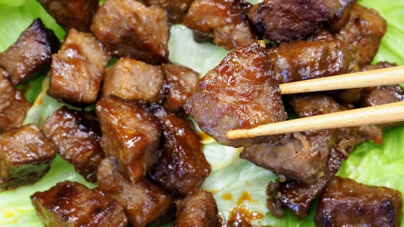 焼いた近江牛の味噌漬けをお箸で一切れ持っている画像
