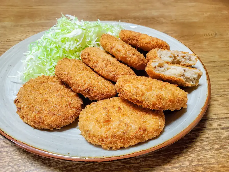 お皿にコロッケとキャベツの千切りを盛りつけた画像