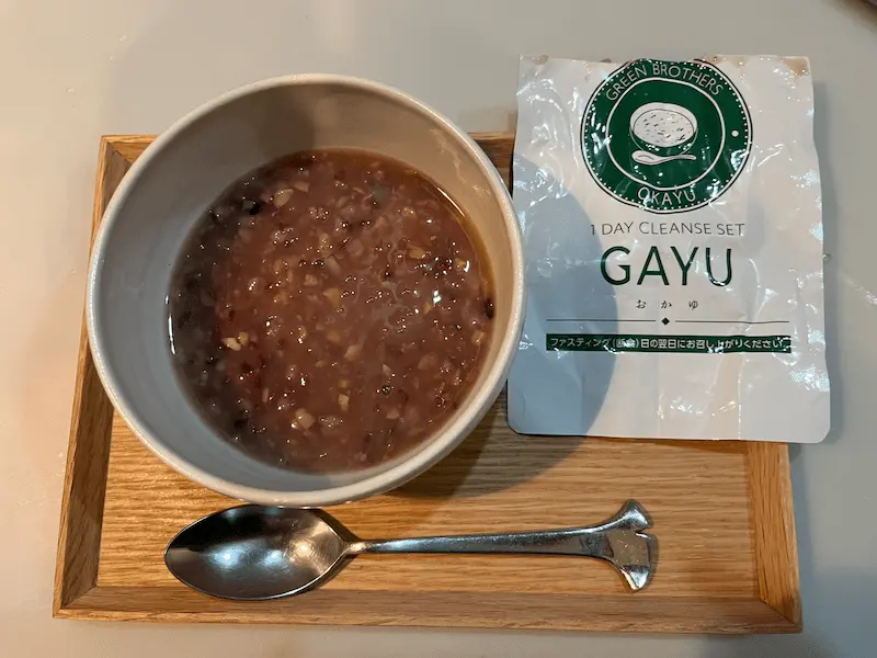 ワンデイクレンズセットのおかゆ「GAYU」を器に盛り、袋と並べた写真